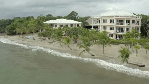 Aerial forward shot of trees by structures at resort, tourists enjoying in Stock Footage 128926574