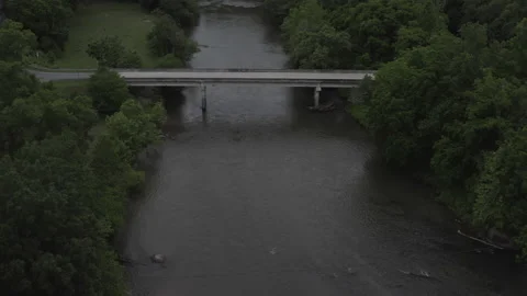 Aerial forward track over river as car passes on bridge 스톡 동영상 133090774