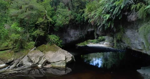 Aerial forward tracking and ascending view of Moria Gate Arch, New zealand Stock Footage 140622464