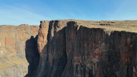 Aerial forward tracking shot of vertical basalt cliffs in Drakensberg mountains Stockbeeldmateriaal 335141630