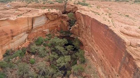 Aerial Forward/Pan Up of Large Hole Surrounded By Cliffs Leading Up To Plain - Stock Footage 109322044