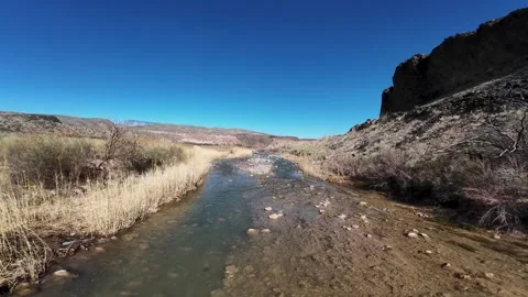 Aerial-FPV-Chasing drone shadow over shallow rocky river Stock Footage 303928231