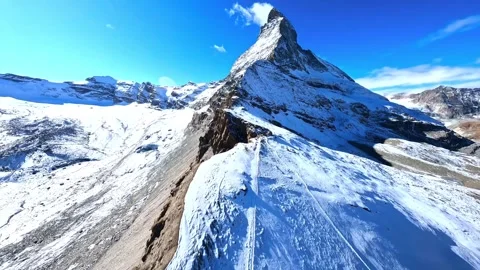 Aerial fpv drone flight towards Matterhorn peak over snowy mountain ridges and Video stock 345716018