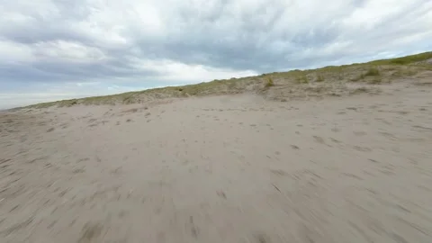 Aerial FPV drone flying through sandy beach dunes at the island of Texel, The Stock Footage 289669031