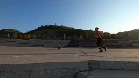 Aerial FPV drone side view of female runner jogging in city embankment in 스톡 동영상 224072709