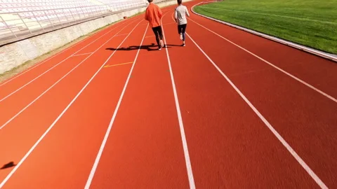 Aerial FPV view of active training couple running together on huge soccer Video stock 167926727