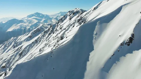 Aerial of freeride snowboarders going down steep slope in soft snow, Chile Stock Footage 121596639