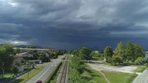 AERIAL: Freight container train shipping logs through idyllic town on stormy day Stock Footage 80930371