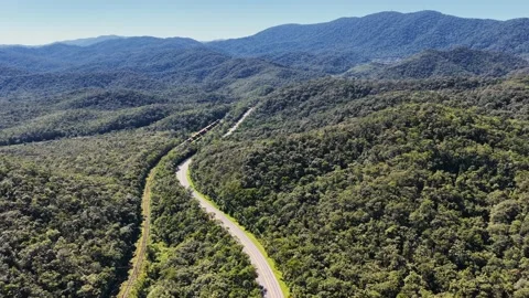 Aerial Freight Train and Winding Highway in Forested Mountains Vídeos de archivo 344690498