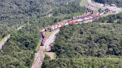 Aerial Freight Train Curving Through Forest Toward Rail Yard Vídeos de archivo 344685933
