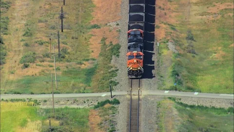 Aerial of freight train running on track through green field, Train East Stock Footage 109462083