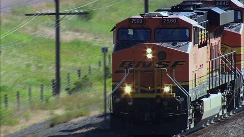 Aerial of freight train running on track through green field, Close on train Stock Footage 109469098