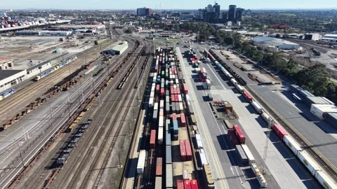 Aerial freight train with shipping containers leaving a railway yard Stock Footage 340381633