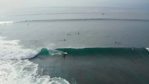 Aerial front view of surfer riding epic wave in Uluwatu Bali 4K Drone Shot Stock Footage 103222383