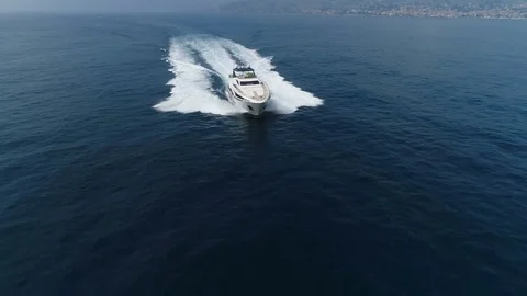 Aerial front view of a yacht navigating fast close to the coast Stock Footage 76256435