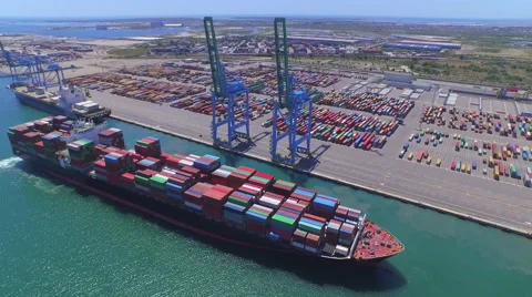 AERIAL: Fully loaded container ship docked at freight port terminal Stock Footage