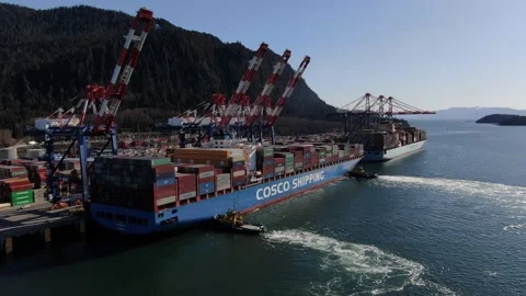 Aerial: Fully loaded container ship with tug boats preparing to depart Stock Footage 149780495