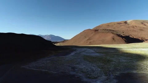 Aerial general view of brown desertic mountains with salar and small vegetation 스톡 동영상 103444849
