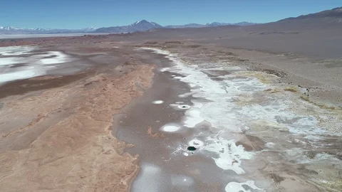 Aerial general view of white salar with water ponds at desert with mountains 動画素材 103437486