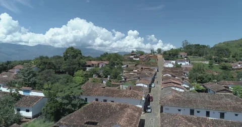 Aerial gliding over the red shingle rooftops of Barichara to the valley Stock-Footage 82536810