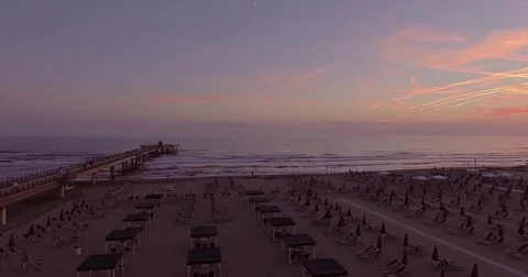 Aerial, gorgeous sunset on empty beach by the pier in Forte dei Marmi, Italy Видео 80599808