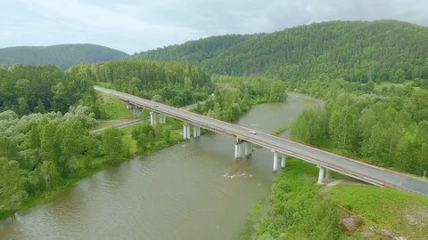 AERIAL: A gray car drives through the bridge across the river. Stock Footage 82222005