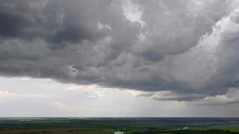 Aerial gray moody clouds above green wheat field Stock Footage 252919924