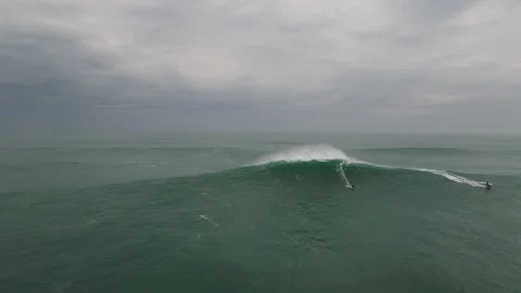 Aerial of group of professional surfers going around atlantic ocean on jet skis Stock Footage 157703953