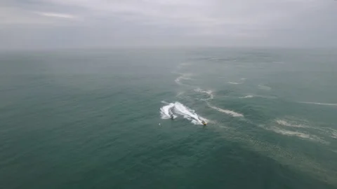 Aerial of group of professional surfers using jet skis to surf on atlantic ocean Stock Footage 157704442
