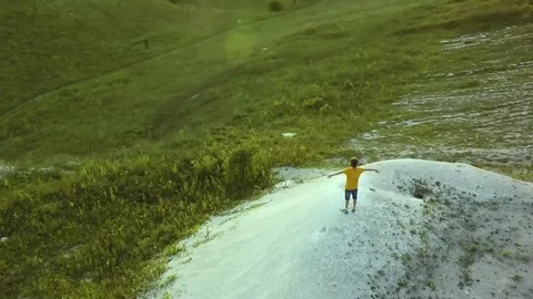 AERIAL:  guy standing on the mountain stretching his hands feel freedom and t Video stock 79407176
