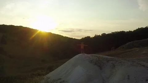 AERIAL:  guy standing on the mountain stretching his hands feel freedom and t Stock-Footage 79407371