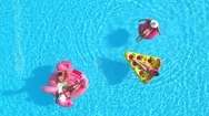 Aerial: Happy Friends Laying On Inflatable Pizza, Doughnut And Flamingo Floats Stock Footage