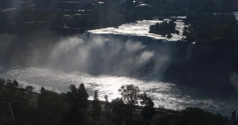Aerial high angle backlit American Falls at sunset, mist rising at golden hour Stock Footage 320025137
