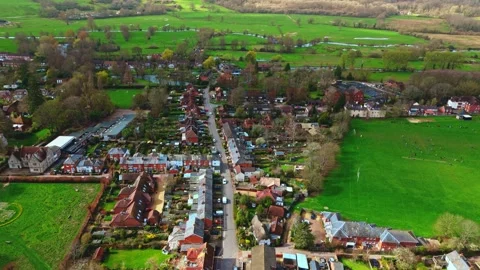 Aerial high angle flyover shot of English suburb village town romsey at sunset Stock Footage 332373124
