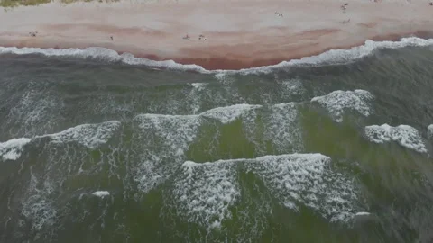 Aerial High Angle Shot Flying Along Shoreline with Waves Crashing on Sandy Beach Stock Footage 321753083