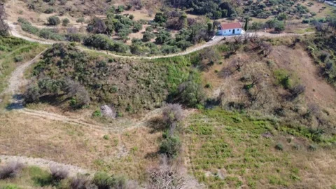 Aerial high angle shot of mountain terrain with olive valley and chapel Stock Footage 344105291