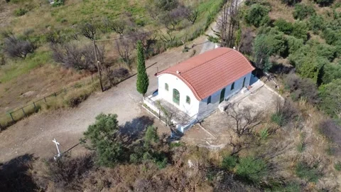 Aerial high angle shot of a white chapel next to a tall cypress tree Stock Footage 344105189