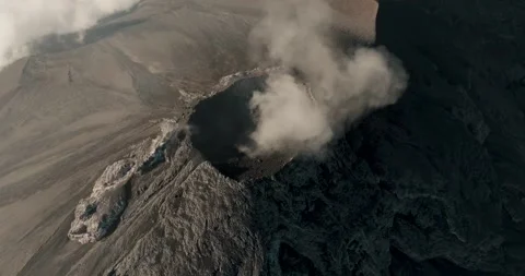 Aerial High Angle View of Grey Volcanic Crater Venting Smoke Stock Footage 322179847