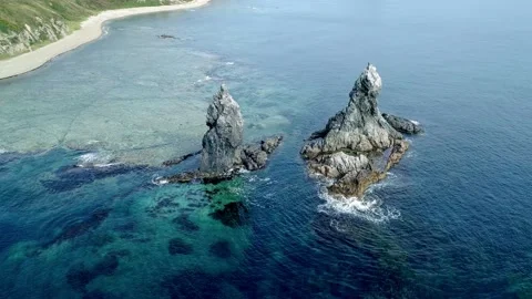 Aerial high angle view of high sea stacks high rocky cliff pillars and Stock Footage 168659420