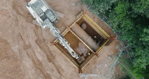Aerial high angle view of hydraulic excavator at pipeline construction site pit Stockbeeldmateriaal 329559123