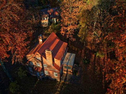 Aerial high-angle view of a large brick house with a red tiled roof nestled a Stock Photos