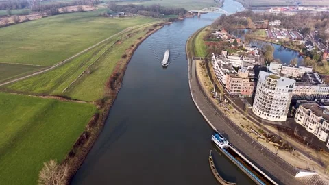 Aerial high angle view of a long cargo barge navigating a winding river through Stock-Footage 330045740