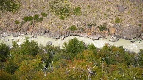 Aerial high angle view of a milky glacial river flowing through  rocky canyon Видео 332988759