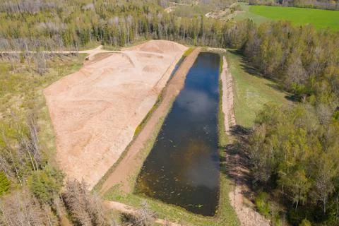 Aerial high angle view of an opencast sand, gravel mine quarry with water Foto stock