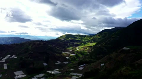 Aerial high angle view over a valley full with meadows and greenhouses Stock Footage 234959484