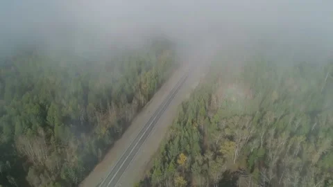 Aerial high angle view through the fog clouds on an intercity road between green Stock Footage 167301421