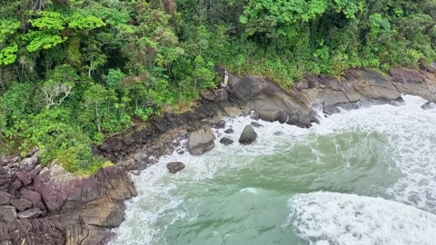 Aerial High Angle View of Waves Crashing Against Rocky Coastline and Sandy Beach Video stock 347222158