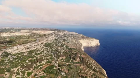 Aerial high angle wide landscape drone shot panning right of the dingli cliffs Stock Footage 336431696