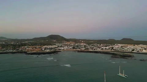 Aerial high level panning view of Corralejo town and harbor at moonset Stock Footage 224037829