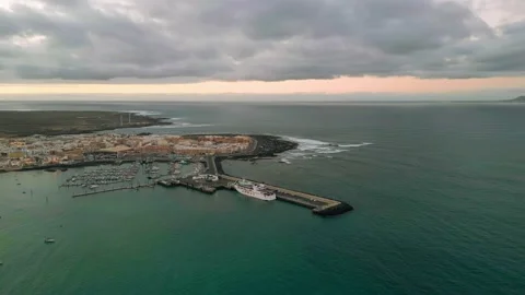Aerial high level panning view of Corralejo town, beaches and harbor at sunset Stock Footage 224037845
